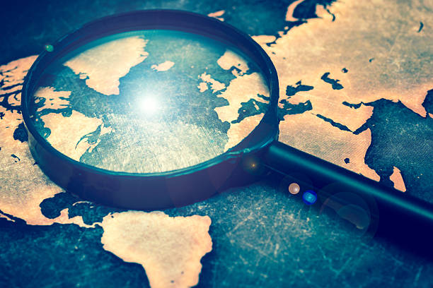 istock Magnifying lens on grunge world map, with lens flare 613540212