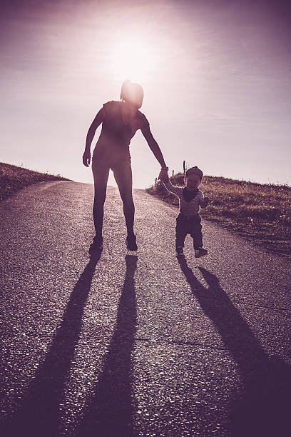istock Baby walking with help of its parents - first steps 613541434