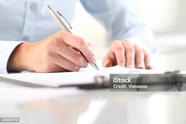 Las Manos De La Mujer Escribiendo En La Hoja En El Portapapeles Con Un Bolígrafo Foto de stock y más banco de imágenes de Llenar el formulario