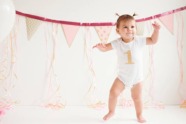 Baby girl's first birthday and first steps stock photo
