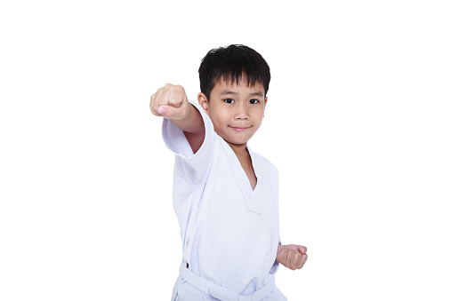 Asian child athletes martial art taekwondo training, isolated on white background. Cute boy with white belt in karate position, studio shot.