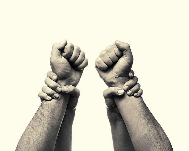 Concept stop violence b-w2 Concept  "stop violence". Women's (children's) hands stop  aggression by the men. This black and white Image is toned and isolated for easy  transfer in your design. fist human hand punching power stock pictures, royalty-free photos & images