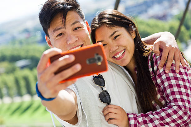 istock Happy young couple using mobile phone in the city. 613545664