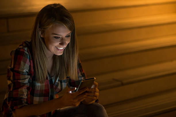 istock Woman using mobile phone in the city, night light background 613546898