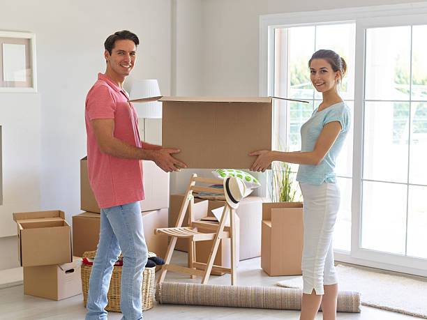 istock Couple carrying cardboard boxes for new home 613547696