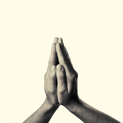 Women's hands folded in prayer on toned background. This black and white image isolated for easy  transfer in your design.