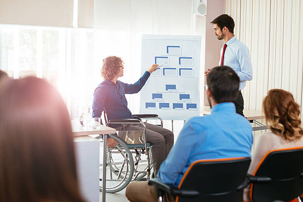 istock Handicapped person on seminar explains corporate hierarchy 613548716