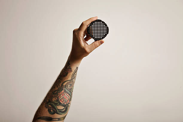istock Tattooed man's hand holding coffee filter cap 613548942