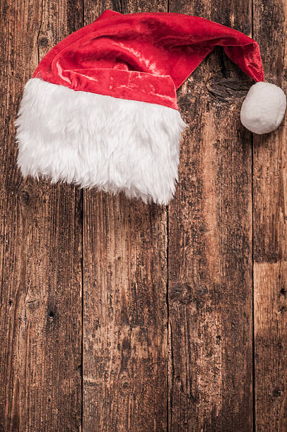 istock Santa red hat on wooden background 613548988