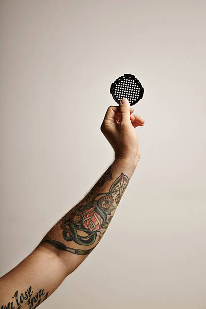 istock Tattoed arm and hand with coffee filter cap 613549034