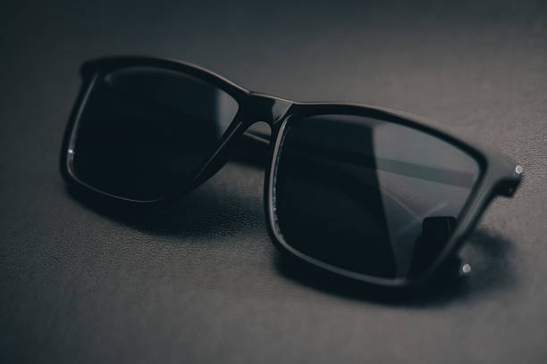 istock Close Up Black Sunglasses on the Black Leather Background 613550088