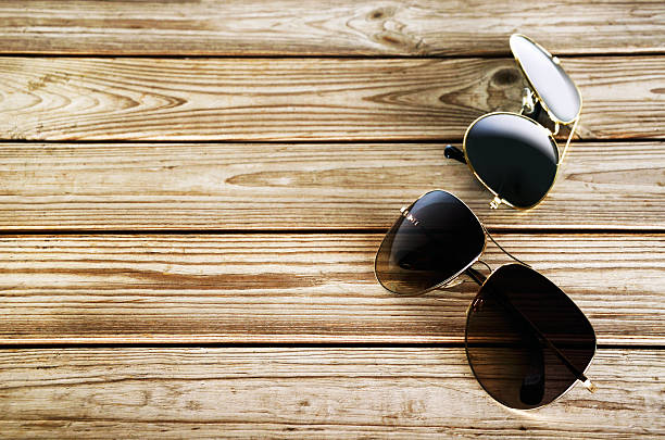 istock two unisex sunglasses on a wooden background top view 613552570