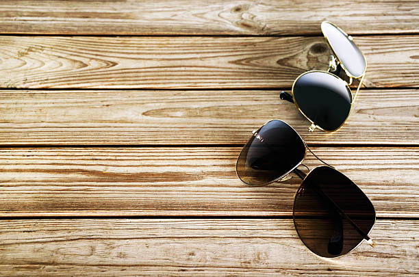 два унисекс солнцезащитные очки на деревянном фоне вид сверху - sunglasses wood black dark стоковые фото и изображения