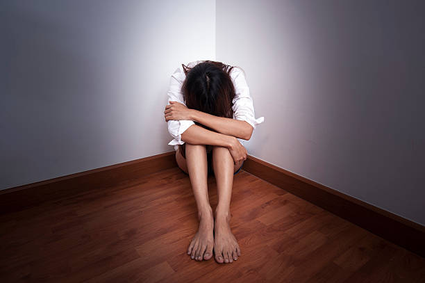 istock Sad woman sitting alone in empty room at the corner 613552900