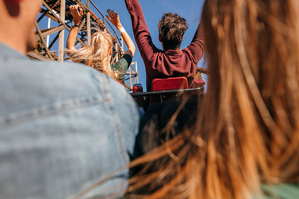 istock Friends on roller coaster ride at amusement park 613553800