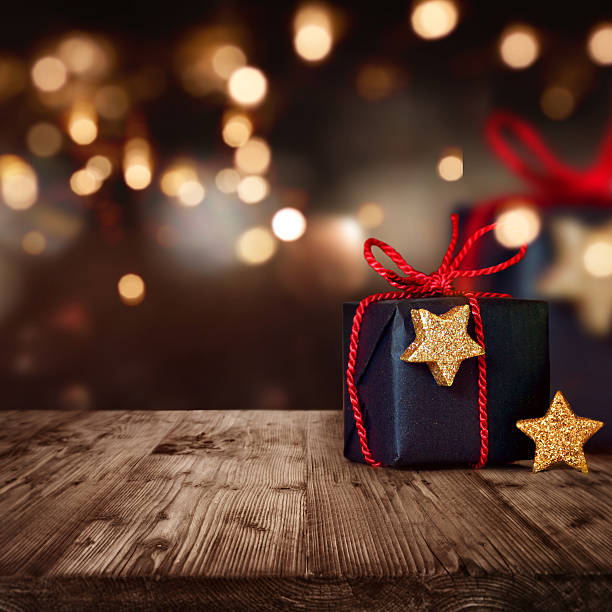 Christmas package with festive Background Christmas package with festive background lights and bokeh stars in your eyes stock pictures, royalty-free photos & images