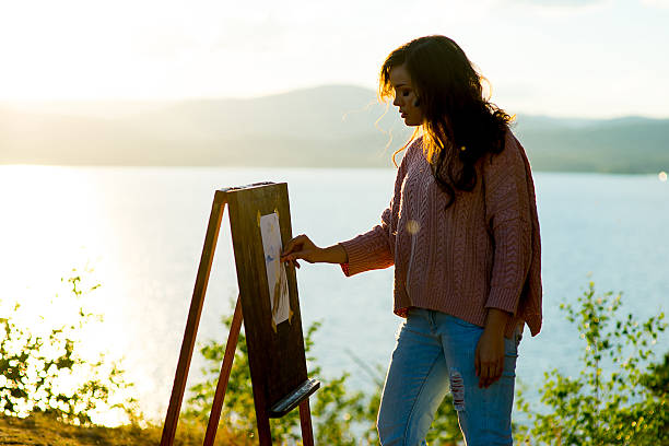 istock young artist draws a seascape at sunset 613554878