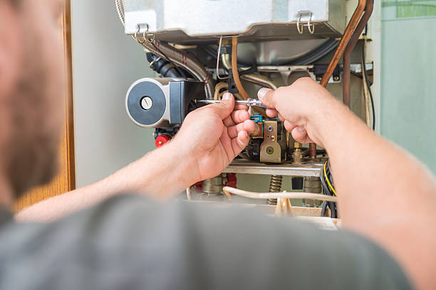 Technician repairing Gas Furnace stock photo