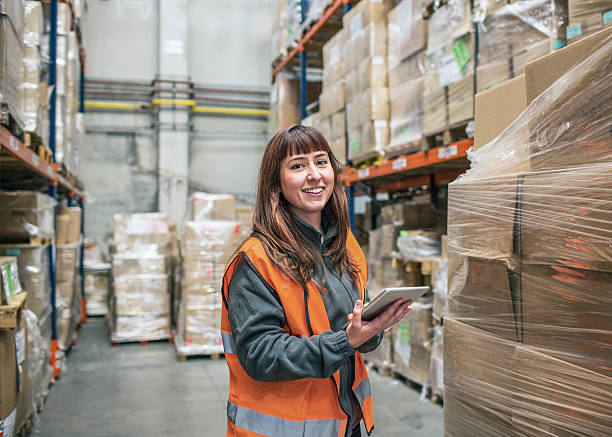 Warehouse delivery check Happy supervisor checking deliveries industrial orange stock pictures, royalty-free photos & images