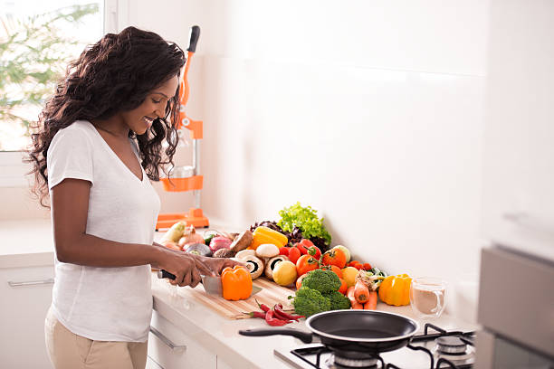 istock Woman chopping bell pepper and other vegetables at kitchen. 613560504