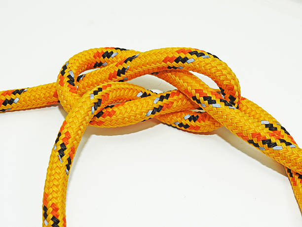 istock Yellow rope with some nodes. Isolated on white background 613561498