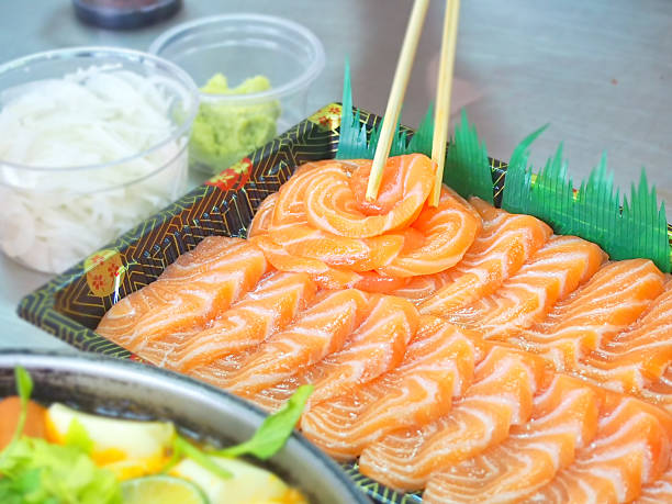 istock chopstick holding a piece of salmon 613652334
