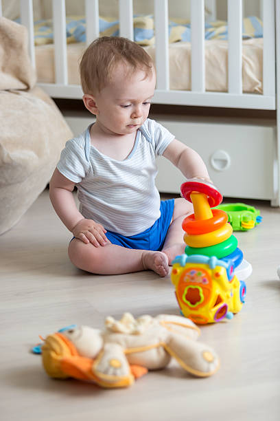 istock Boy assembling colorful pyramid on floor at living rom 613652458
