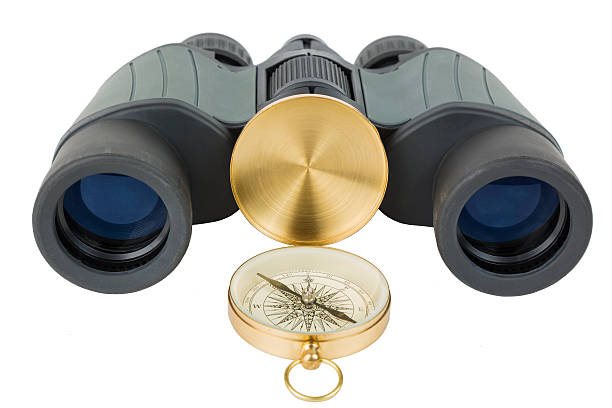istock Travel concept. Binoculars near compass. Isolated on white. 613653264