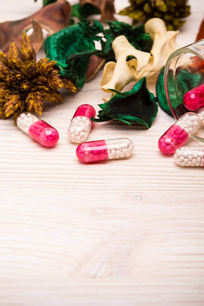 Pink capsules with green and orange leaves portrait stock photo