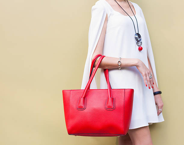 модная большая красная сумочка на руке девушки - wall women leather street стоковые фото и изображения