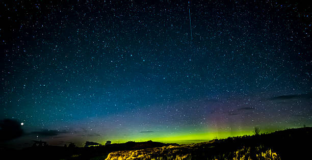 Isle of Skye Northern Lights and stars Looking northwards in the Isle of Skye Scotland to the beautiful colors of the night sky showing thousands of stars, satellites and the Northern Lights, Aurora Borealis. Big Dipper or Plough constellation in the center while the brightest star in the bottom left is Arcturus. isle of skye stock pictures, royalty-free photos & images