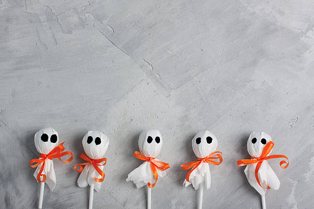 istock Halloween lollipop ghosts on gray concrete background 613656654