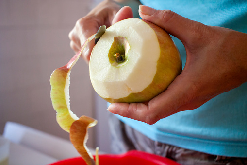 Mujer pelando manzanas en la cocina photo