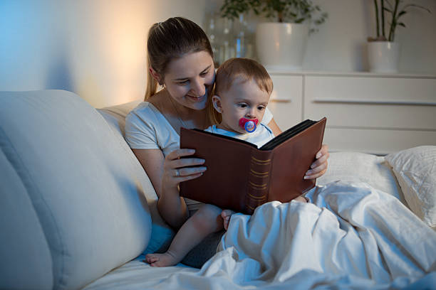 istock Mother and baby reading book before going to sleep 613659996
