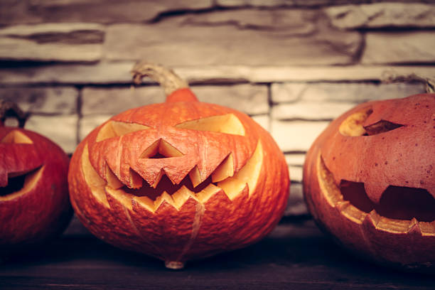 istock Halloween pumpkins on stone background 613660508