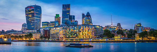 London futuristic skyscrapers glittering at sunset overlooking River Thames UK Sweeping panoramic sunset across the River Thames at London Bridge, reflecting the illuminated skyscrapers of the City, the office buildings of the Embankment and the futuristic towers of the Walkie Talkie and the Cheesegrater in the heart of the UK's vibrant capital city. 20 fenchurch street photos stock pictures, royalty-free photos & images