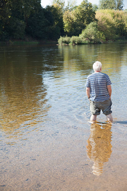 istock senior man has fun paddling in river 613663018