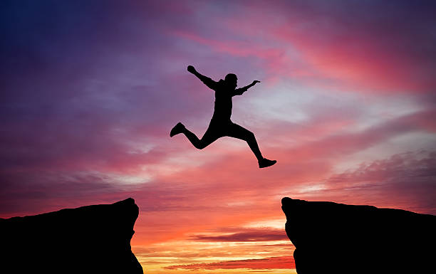 istock Man jumping across the gap 613663852