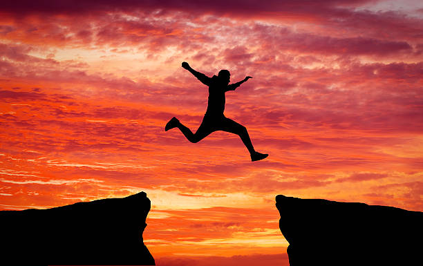 istock Man jumping across the gap 613663884