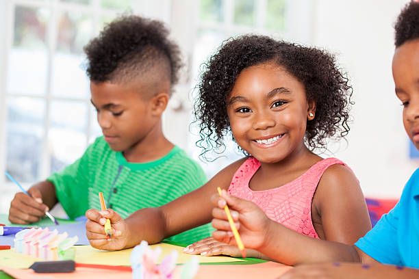 istock Cute kindergarten girl paints during art class 613665596