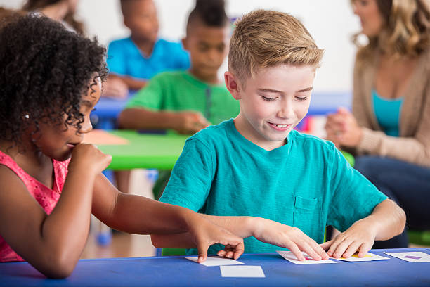 Kindergarten students play with flash cards African American and Caucasian kindergarten  students play with flash cards during class.. discover card stock pictures, royalty-free photos & images