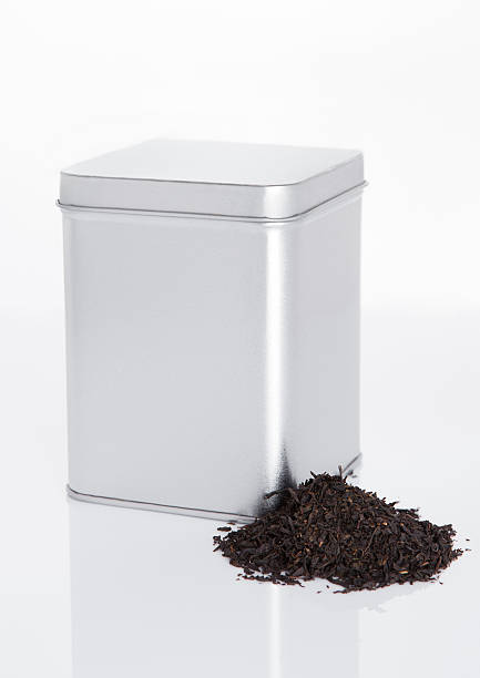 istock Black tea steel jar with loose tea next to it 613665830