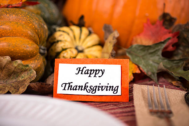 istock Happy Thanksgiving place setting with autumn centerpiece on table. 613666236