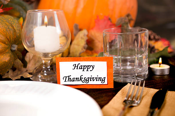 istock Happy Thanksgiving place setting with autumn centerpiece on table. 613667850