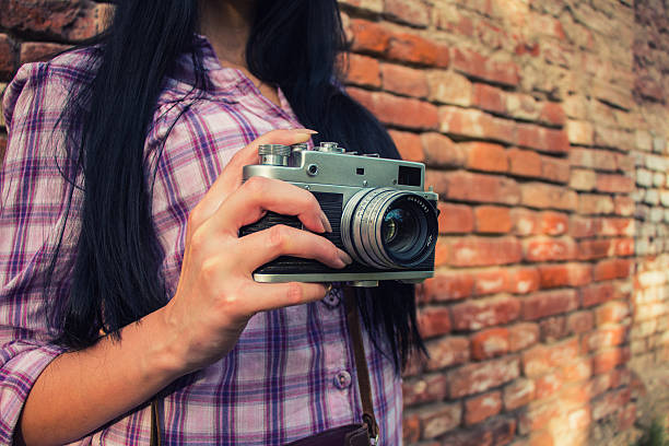 beautiful  girl shooting with retro camera - photographer enjoyment elegance old fashioned imagens e fotografias de stock