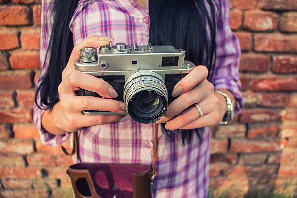 istock Beautiful  girl shooting with retro camera 613668554