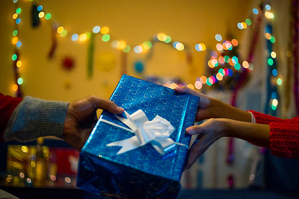istock Human hands holding gift - giving and taking  a gift. 613668698
