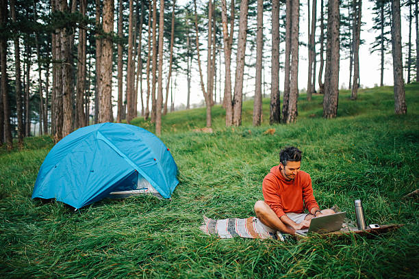 istock Young man camping in the forest 613668824