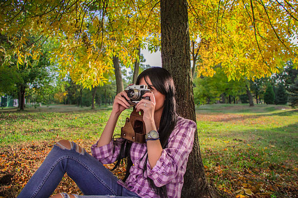 istock Beautiful  girl shooting with retro camera 613669506