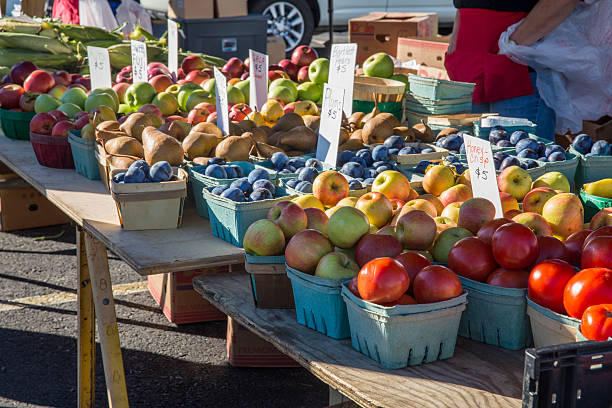Fresh, juicy yellow and red pears on the stall surrounded with other fresh fruits and vegetables. Close up. Defocused background.